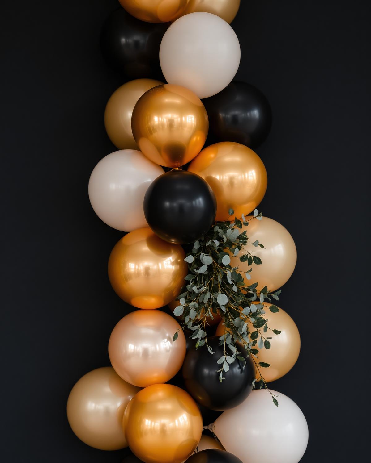 Detail van een organische ballonslinger in goud, zwart en ivoor met eucalyptus