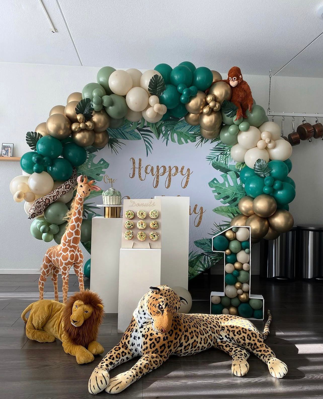 Safari-decor met ballonboog in groen en goud en dierfiguren
